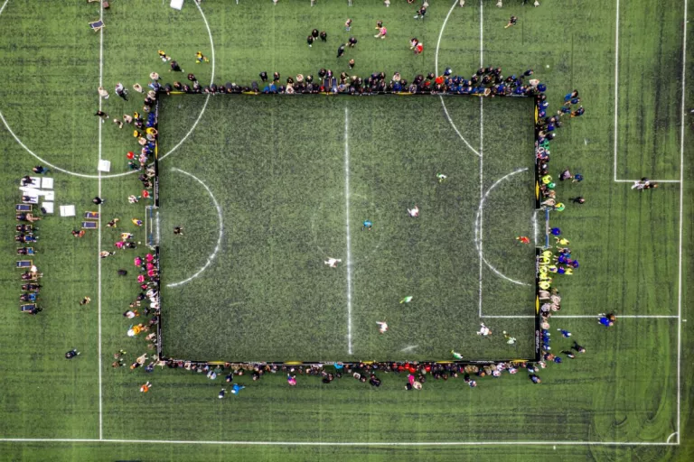 Terrain de foot vert avec des personnes autour