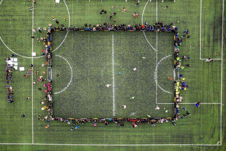 Terrain de foot vert avec des personnes autour