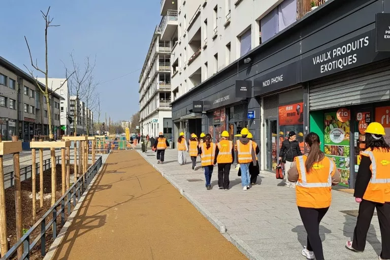 Jeunes marchant dans une rue avec des gilets oranges