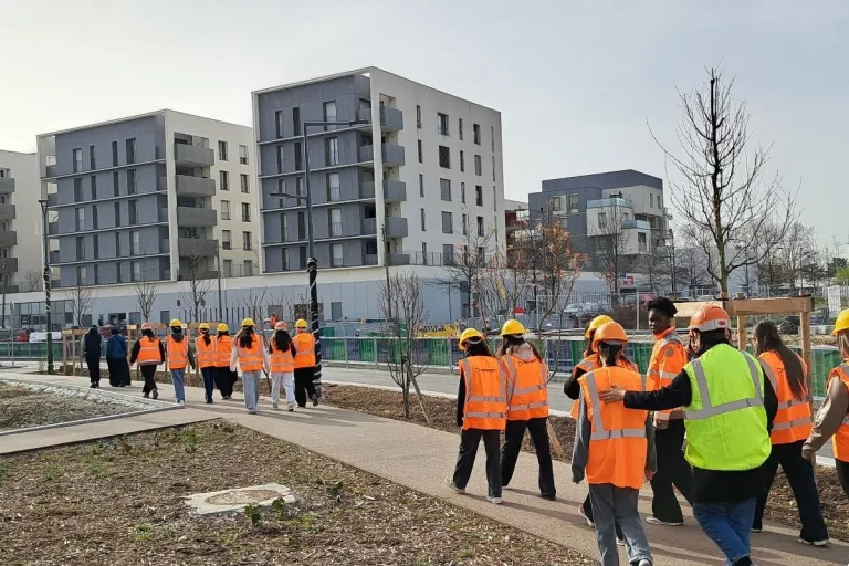 Personnes qui marchent sur un chemin en groupe avec des gilets oranges