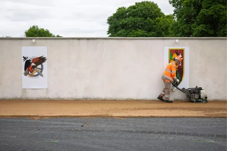 collaborateur qui compacte de l'enrobé avec une machiens ur un chantier Colas