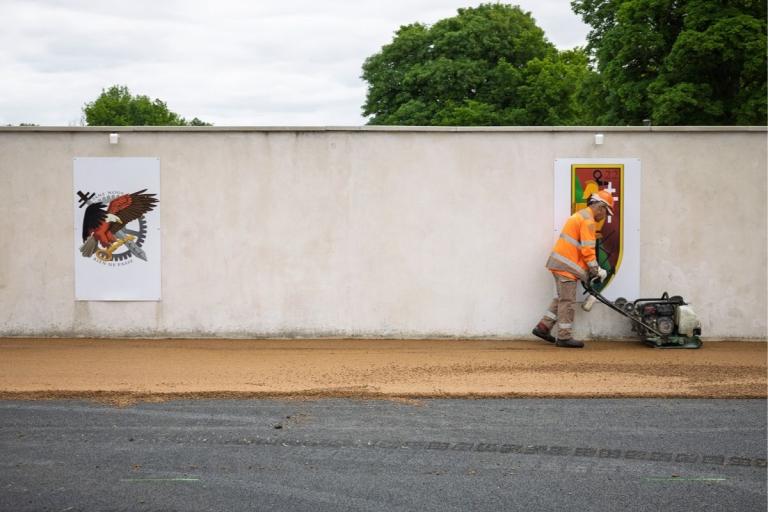 collaborateur qui compacte de l'enrobé avec une machiens ur un chantier Colas