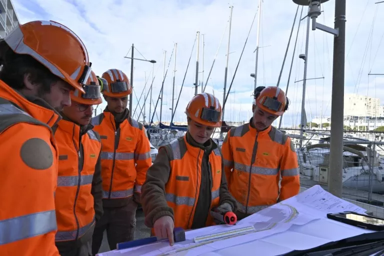 plsuieurs collaborateurs Colas sur chantier qui regardent un plan