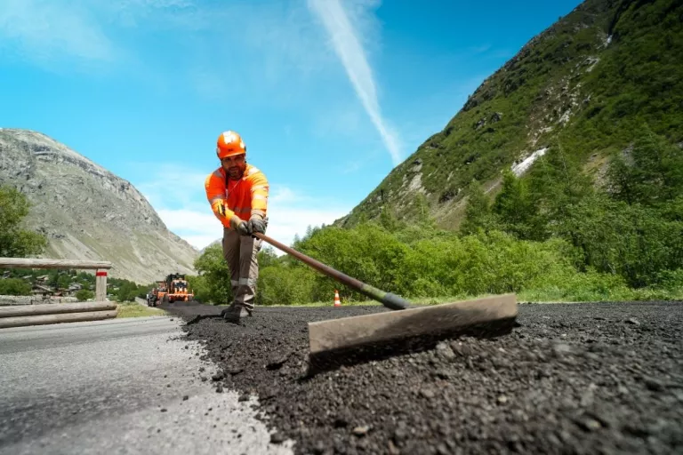 Un ouvrier Colas met en œuvre un revêtement recyclé avec la solution Recycol sur la route de Bonneval-sur-Arc.