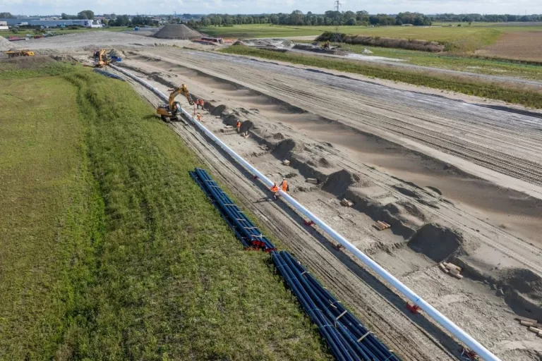 Vue aérienne d’un chantier SPAC avec pose d’une longue canalisation dans une zone de terrassement.