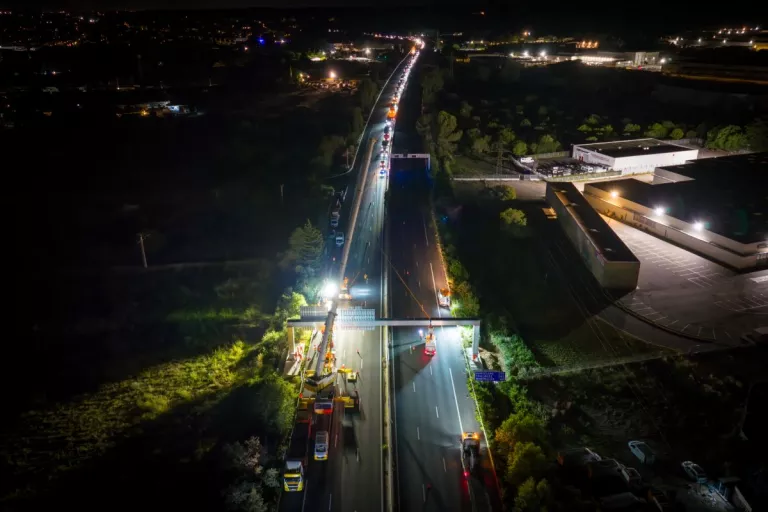 Vue aérienne de nuit montrant le chantier de pose d'un portique de signalisation sur l'autoroute A9.