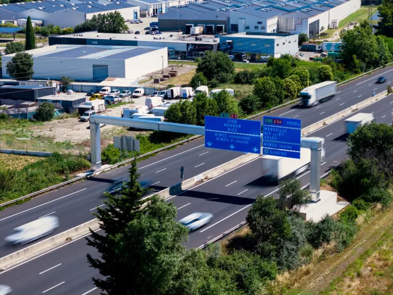 Vue aérienne de jour du nouveau portique de signalisation installé au-dessus de l'autoroute A9 après les travaux.