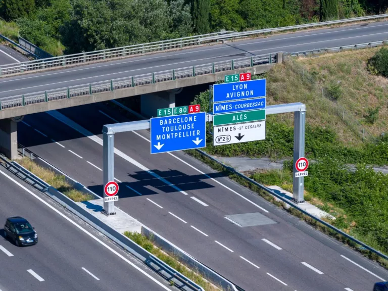 Portique de signalisation neuf installé sur l'autoroute A9 avec panneaux directionnels vers Lyon, Avignon, Barcelone et Montpellier.