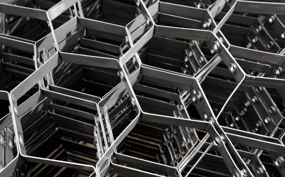 Gros plan graphique d’un empilement de structures métalliques alvéolaires formant un motif hexagonal.