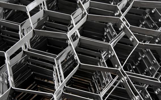 Gros plan graphique d’un empilement de structures métalliques alvéolaires formant un motif hexagonal.