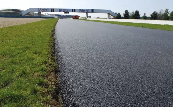 Une piste fraîchement asphaltée s’étire vers un pont brandissant la signalétique Mobil 1, prête pour la vitesse et la performance.