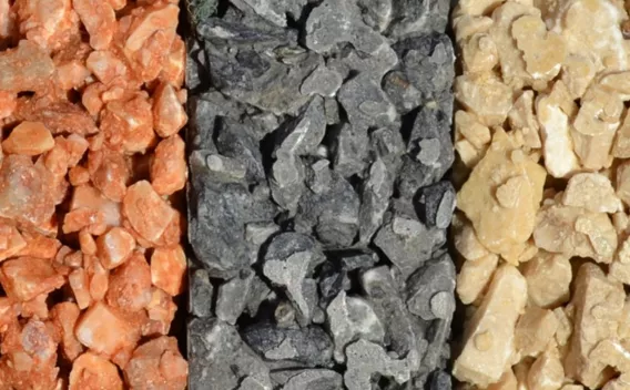 Granulats décoratifs enrobés liés au liant bitumineux, trois teintes (ocre, gris, beige) pour finition de couche de roulement ou gravillonnage esthétique.