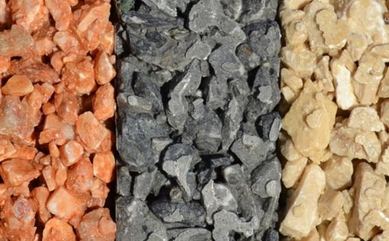 Granulats décoratifs enrobés liés au liant bitumineux, trois teintes (ocre, gris, beige) pour finition de couche de roulement ou gravillonnage esthétique.