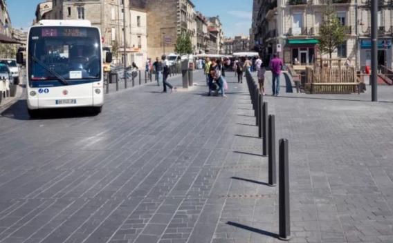 Pôle intermodal devant gare avec voies bus dédiées, îlots piétons protégés et signalétique claire favorisant correspondances sûres et fluides.