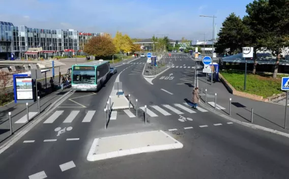 Quai multimodal organisé avec voies bus dédiées, traversées piétonnes et pistes cyclables sécurisées facilitant l'accès à la gare.