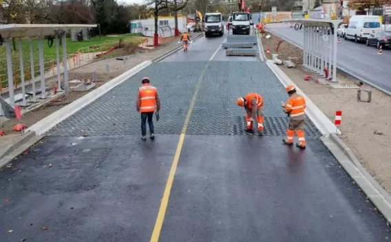 Équipe de pose installant des modules alvéolaires sur une section de route pour optimiser drainage et stabilité du revêtement.