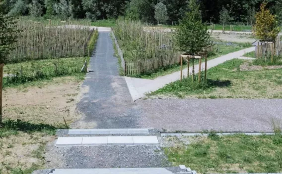 Sentier piéton et pistes multifonctions aménagées en milieu paysager avec bordures, accès modulés et plantations favorisant la circulation douce et l'intégration écologique.