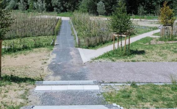 Sentier piéton et pistes multifonctions aménagées en milieu paysager avec bordures, accès modulés et plantations favorisant la circulation douce et l'intégration écologique.