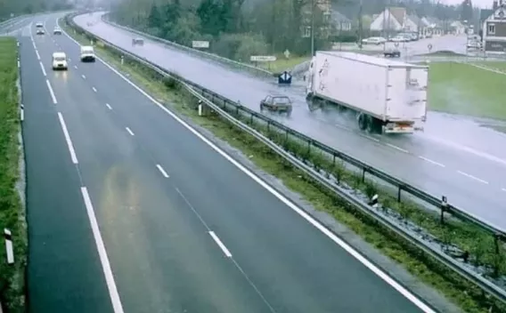 Pose d'un enrobé par finisseur sur chaussée en milieu rural : épandage et compactage de la couche de roulement.