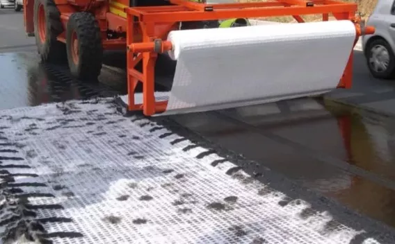 Travaux de démolition intérieure avec mini-pelle opérée par un salarié en EPI retirant cloisons et débris dans un espace en cours de reprise.