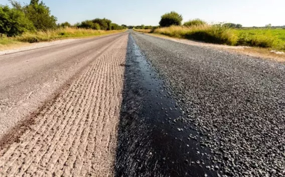 Application d’une couche de roulement par gravillonnage en milieu rural : liant posé sur surface fraisée puis gravillons épandus.
