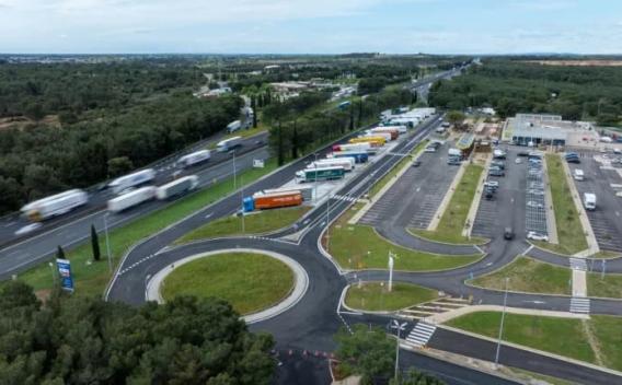 Travaux de voirie et aménagements (pose d’enrobé, trottoirs, accotements, compactage) avec équipes en EPI, engins et zones de chantier balisées.