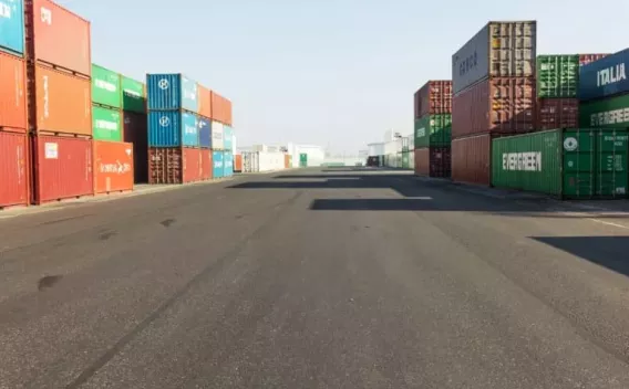 Deux ouvriers en EPI assemblent un raccord de canalisation dans une tranchée, respectant les procédures de sécurité.