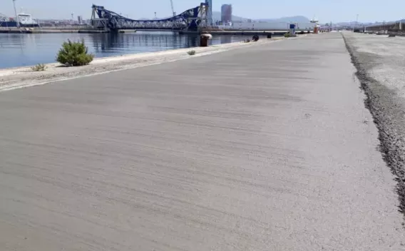 Revêtement béton lisse sur quai portuaire, offrant résistance aux charges lourdes et conditions maritimes.