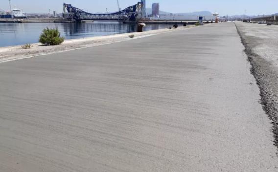 Revêtement béton lisse sur quai portuaire, offrant résistance aux charges lourdes et conditions maritimes.