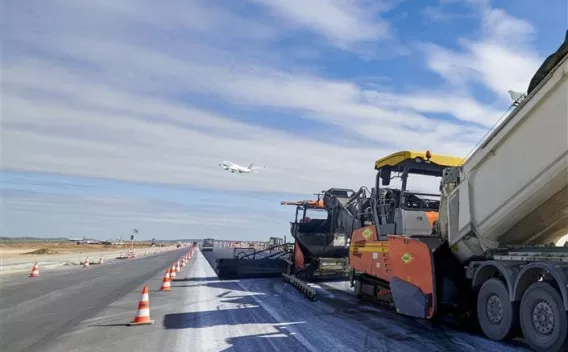 Piste 1 aéroport de Roissy-Charles de Gaulle : Rabattage et finissage d'une piste d'aéroport sous un ciel animé, machines alignées et logistique coordonnée pour assurer une reprise du trafic en toute sécurité.