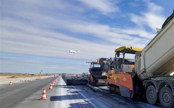 Piste 1 aéroport de Roissy-Charles de Gaulle : Rabattage et finissage d'une piste d'aéroport sous un ciel animé, machines alignées et logistique coordonnée pour assurer une reprise du trafic en toute sécurité.