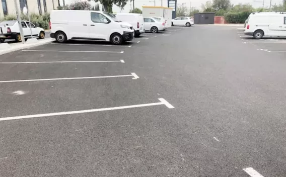 Mise en œuvre d’un réseau de canalisation bleue : opérateur en EPI procédant au montage et au serrage d’un coude sur lit granulaire, assurant la continuité et l’étanchéité du branchement dans un chantier organisé.