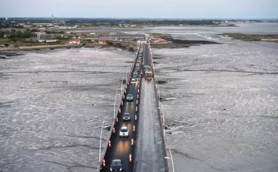 Travaux de nuit sur un pont : circulation alternée, balisage et reprise de la chaussée par chaussée partiellement fraîchement revêtue.