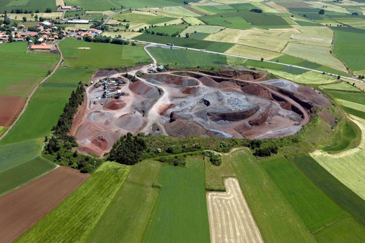 Vue aérienne de la carrière de Bizac, entourée de champs, avec ses zones d’extraction et ses installations de traitement.