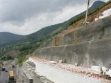 Mur de soutènement en blocs polystyrène (terre‑armée) empilés avec terrassement et préparation de l'assise routière.