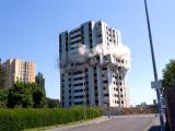 Démolition contrôlée d’une tour d’habitation par foudroyage, séquences d’explosion maitrisées et périmètre de sécurité établi pour l’abattage de la structure.