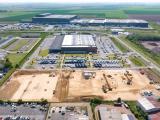Création d_un parking VL pour Amazon - Lille : Terrassement de grande emprise sur parcelle industrielle en cours : surface nivelée, engins de terrassement répartis et voies d'accès préparées pour futur bâtiment logistique.