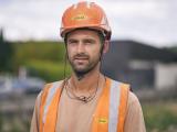 Portrait d'un collaborateur Colas sur chantier : Ouvrier de chantier équipé d’EPI (casque, gilet haute visibilité et micro), illustrant sécurité, professionnalisme et savoir‑faire sur site.