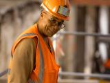 Réhabilitation d'un immeuble de la Matmut : Ouvrier sur chantier en gilet haute visibilité et casque, illustrant sécurité, vigilance et travail en milieu construit.