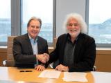 Acquisition de Hubert Rougeot Meursault par Colas France : Signature d’un partenariat en salle de réunion: deux dirigeants scellent l’accord par une poignée de main au-dessus des documents paraphés.