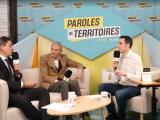 3 personnes échangeant avec un micro sur des canapés avec un logo Paroles de Territoires