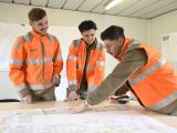 3 jeunes collaborateurs avec des gilets oranges